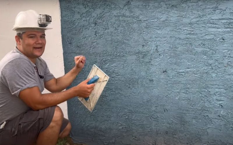 Frame de vídeo onde um pedreiro ensina técnica de pintura para deixar a parede bonita sem gastar muito