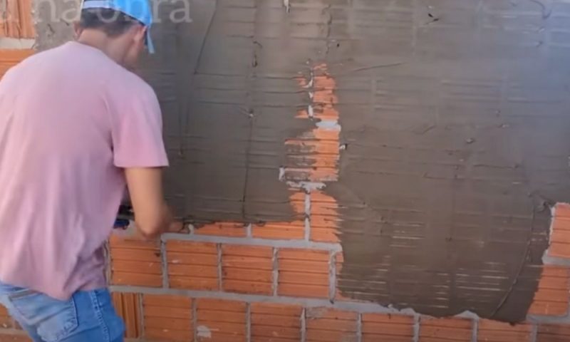 Pedreiro passa a primeira mão de argamassa para dar base à textura