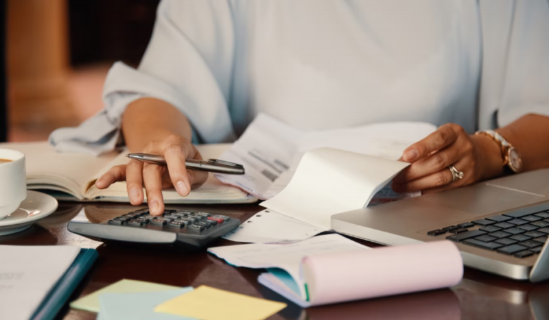 Pessoa fazendo cálculos, algo comum para famílias endividadas que tem a vida diretamente impactada pela alta da taxa selic