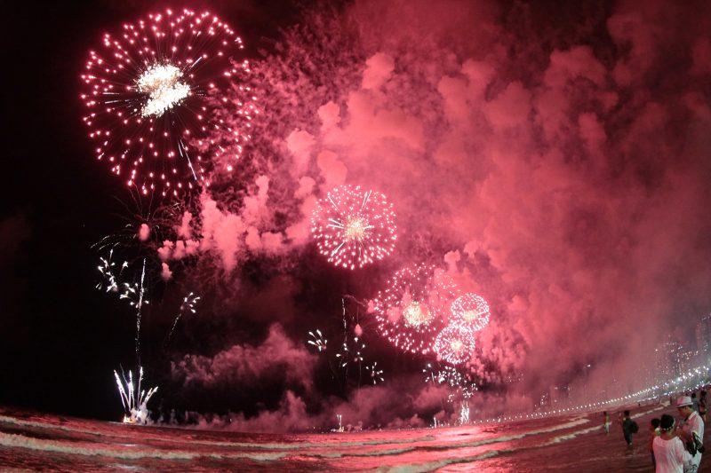 Fogos de artifício vermelhos explodindo no ar durante réveillon em Balneário Camboriú