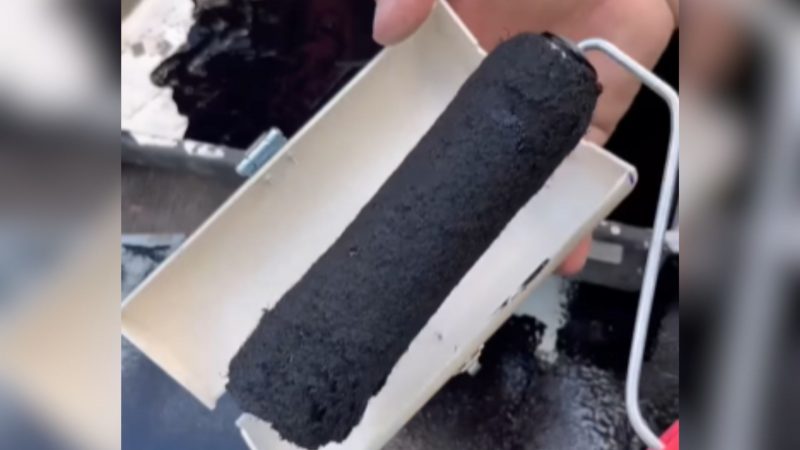 Pintor segurando rolo de pintura e caixinha para guardá-lo