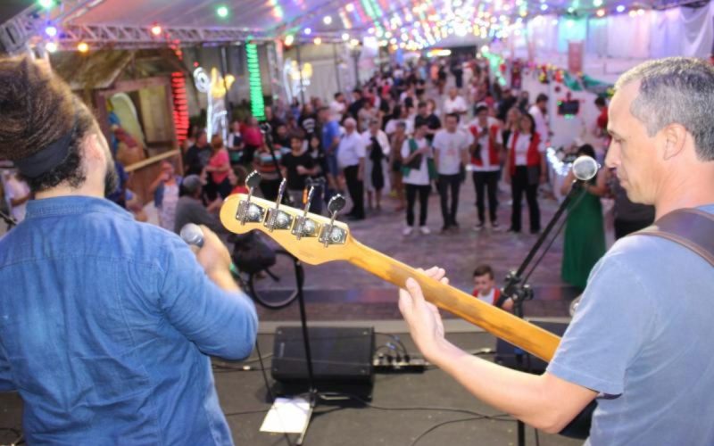 Cantor e guitarrista tocando para plateia na Rua Coberta, programação do Natal EnCanto de Itajaí