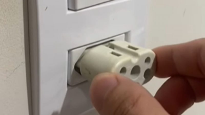 Rapaz colocando adaptadores em tomada 