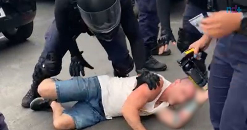 imagem mostra motorista de aplicativo no chão durante abordagem da Guarda Municipal