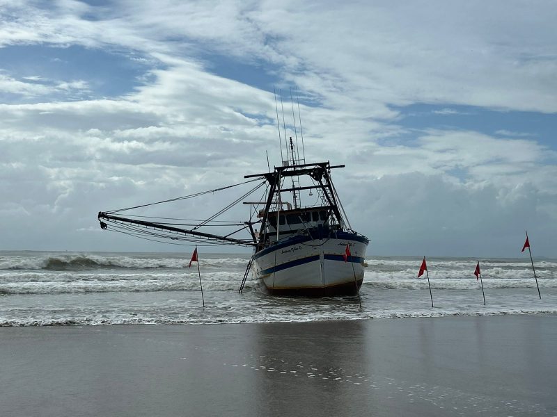 Imagem mostra barco encalhado bem de perto na praia Central de Navegantes