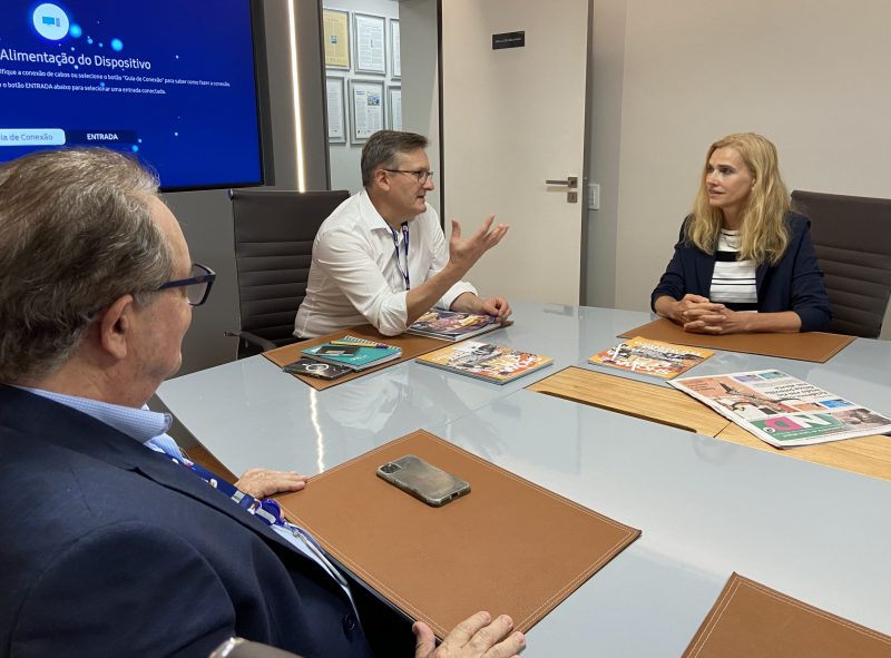 Foto mostra três pessoas sentadas em uma mesa conversando. Luís Meneghim, diretor de conteúdo, Roberto Bertolin, diretor regional Marian Schurgraf,  Embaixadora da União Europeia no Brasil.