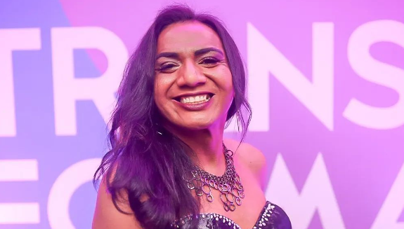 Drica D’arc Meirelles - Mulher negra de cabelos escuros e médios sorrindo