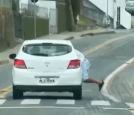 Homem fica pendurado em porta de carro em Blumenau