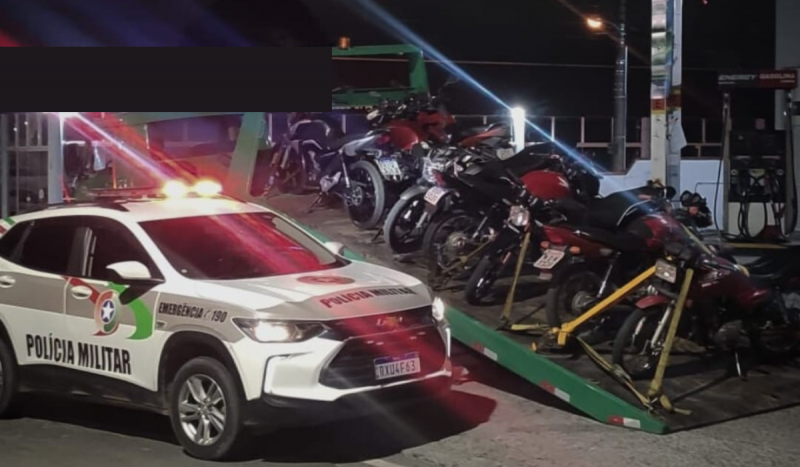 Motoqueiro foi preso em Lages - Na foto, viatura da PM de SC ao lado de guincho removendo 14 motos em cima de uma plataforma de reboque