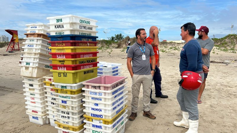 Imagem mostra equipe articulando para retirada do pescado do barco encalhado