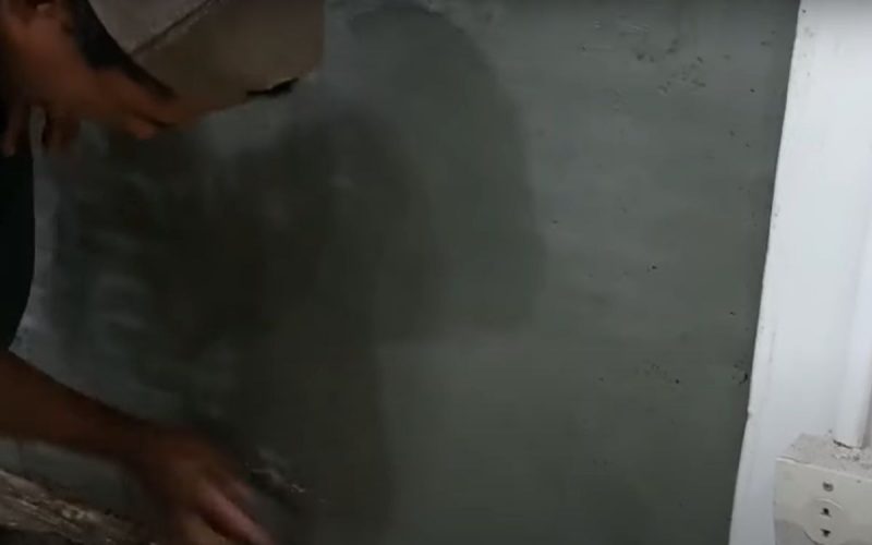 Frame de vídeo em que pedreiro ensina a fazer reboco rápido de parede