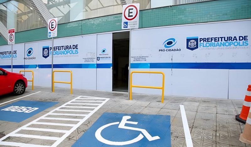 Fachada da Secretaria da Fazenda de Florianópolis. Na foto é possível ver uma vaga de estacionamento para deficientes e outra para pessoas idosas em frente ao prédio