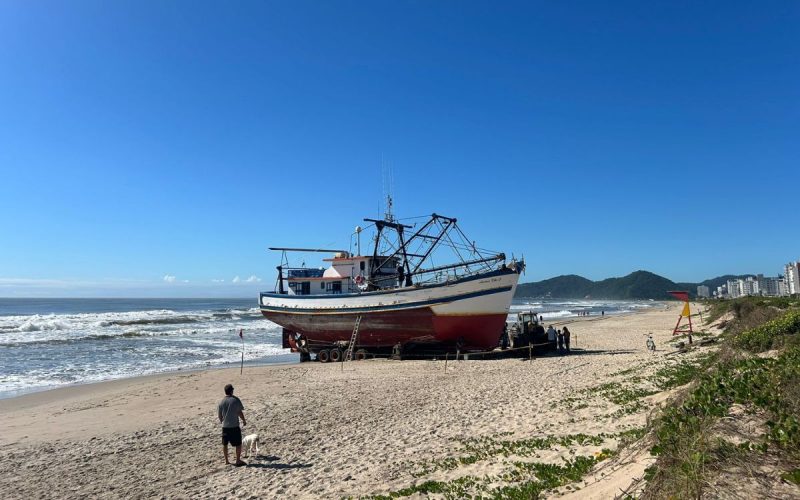Barco encalhado na Praia Central de Navegantes durante processo de remoção