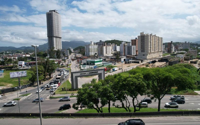 Imagem panorâmica de Camboriú, com imóveis ao fundo, durante a tarde