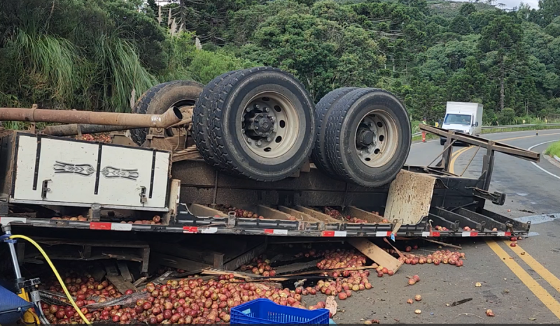 Caminhão com maçãs tombado na pista