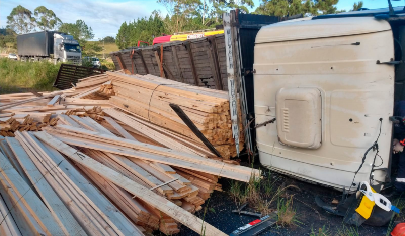 Madeira caindo de compartimento de carga de carreta após acidente