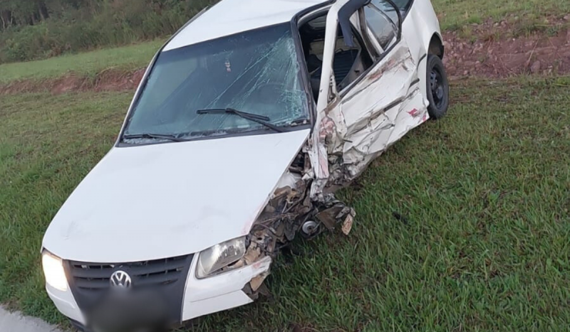 Carro branco amassado após colisão