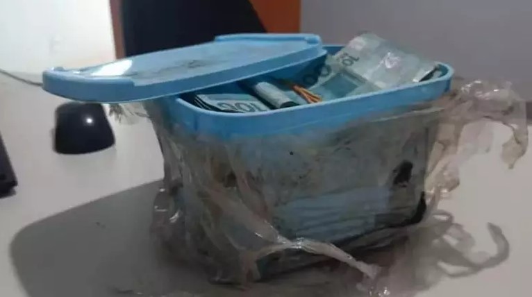 Pote de sorvete enterrado no quintal da resid&ecirc;ncia com R$ 60 mil dentro – Foto: Pol&iacute;cia Civil/Divulga&ccedil;&atilde;o/ND