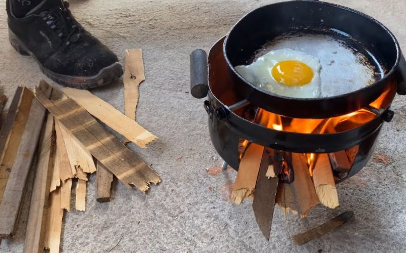 Frame de vídeo em que um pedreiro ensina como fazer um fogão a lenha usando panela velha