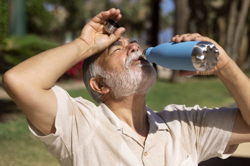 Homem se hidrata em meio ao calor