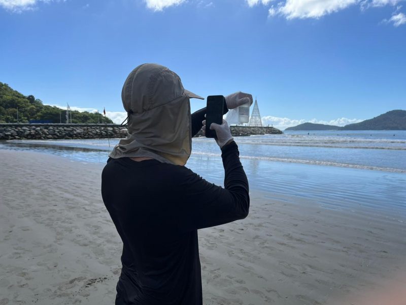 imagem de agente da emasa fazendo coleta na praia de balneário camboriú 