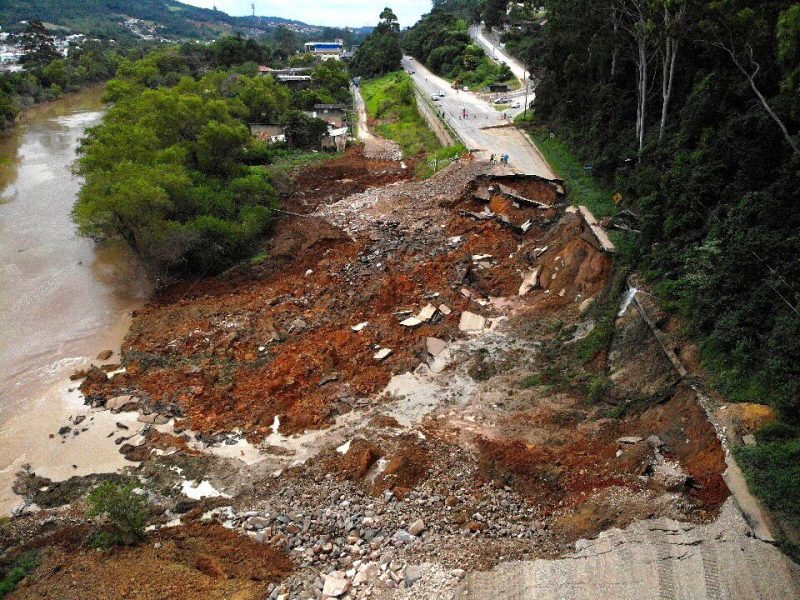 Foto aérea mostra cratera gigantesca aberta no meio de uma estrada