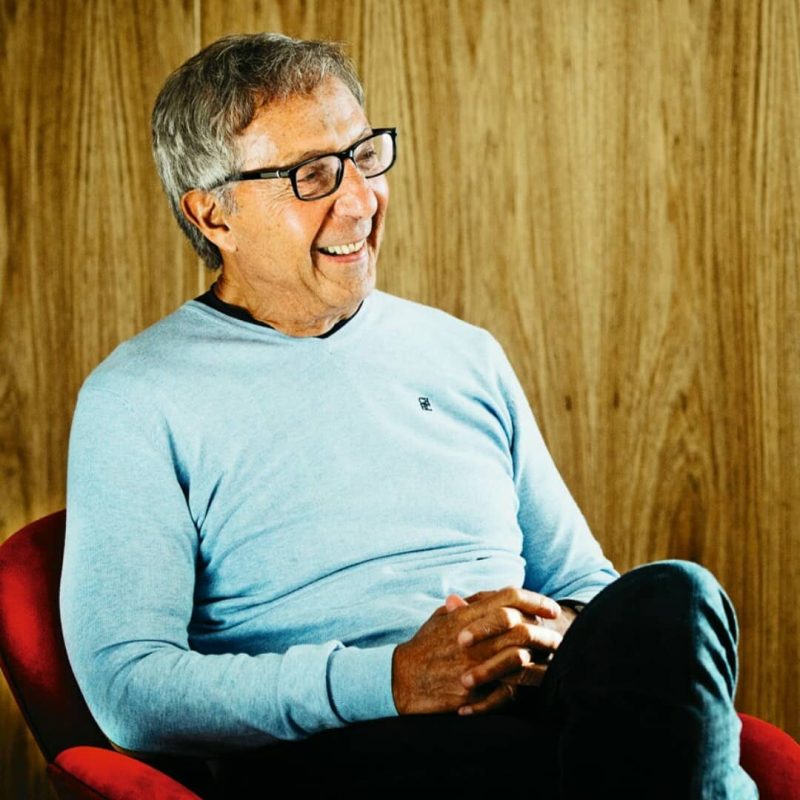 Foto mostra Abilio Diniz sentado sorrindo