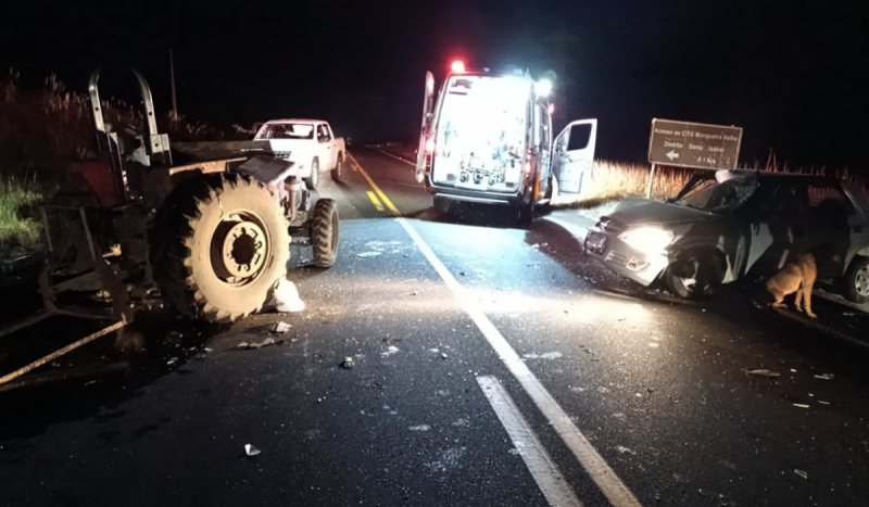 Trator, ambulância e carro cinza parados na pista 