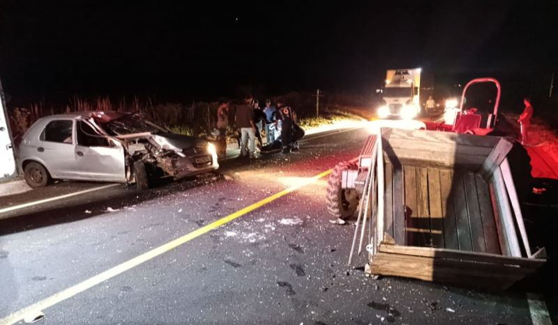 Foto mostra carro cinza destruído e trator na pista após colisão em SC