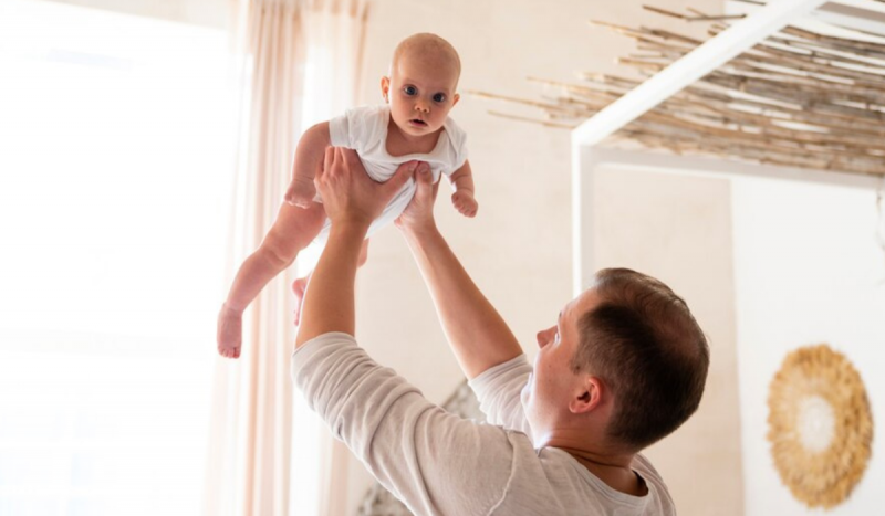 Síndrome do Bebê Sacudido - Bebê da cor branca sendo carregado no ar por um homem adulto branco
