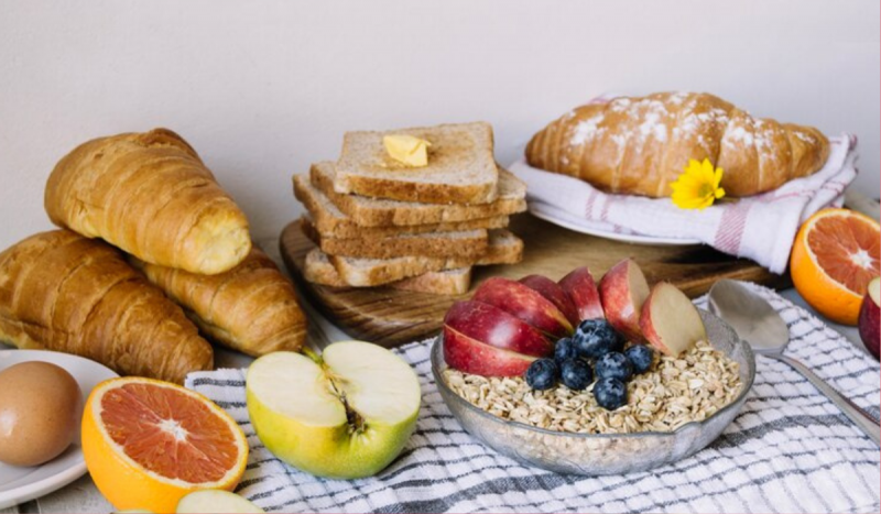 Mesa com pães e frutas em cima de pano branco quadriculado