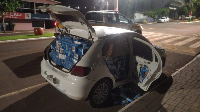 Carro branco lotado de maços de cigarro