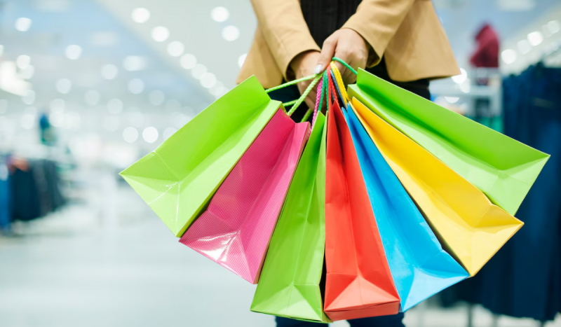 Sacolas de compras coloridas sendo seguradas em uma mão - imagem é utilizada para ilustrar matéria sobre semana do consumidor