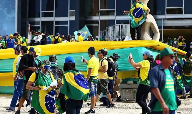 Atos de 8 de janeiro, foto mostra manifestantes na praça dos três poderes vestidos de verde e amarelo e com bandeiras do brasil