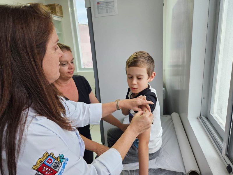 na imagem aparece a enfermeira dando injeção em um menino para não pegar sarampo