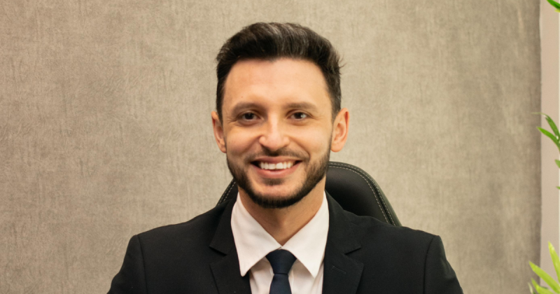 A foto mostra o advogado Maikon Rafael Matoso - um homem branco, com cabelo castanho e barba. Ele está sorrindo e usando um terno.