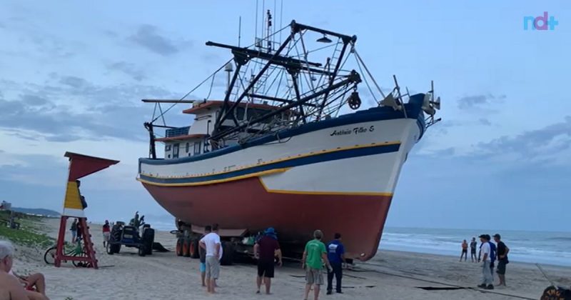 Imagem mostra operação para retirar barco encalhado na praia de Navegantes