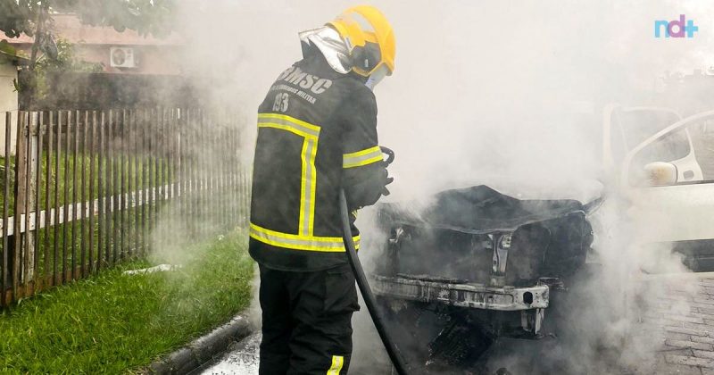 Imagem mostra bombeiro atuando no combate ao incêndio em carro