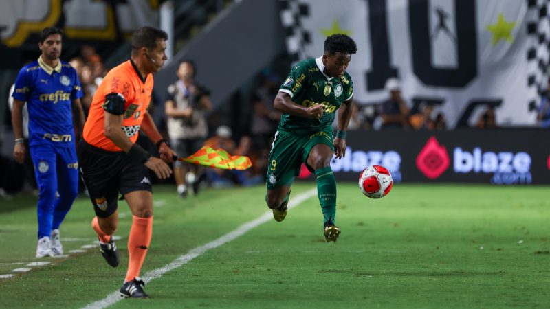 Endrick conduz a bola durante jogo do Palmeiras enquanto Abel Ferreira observa