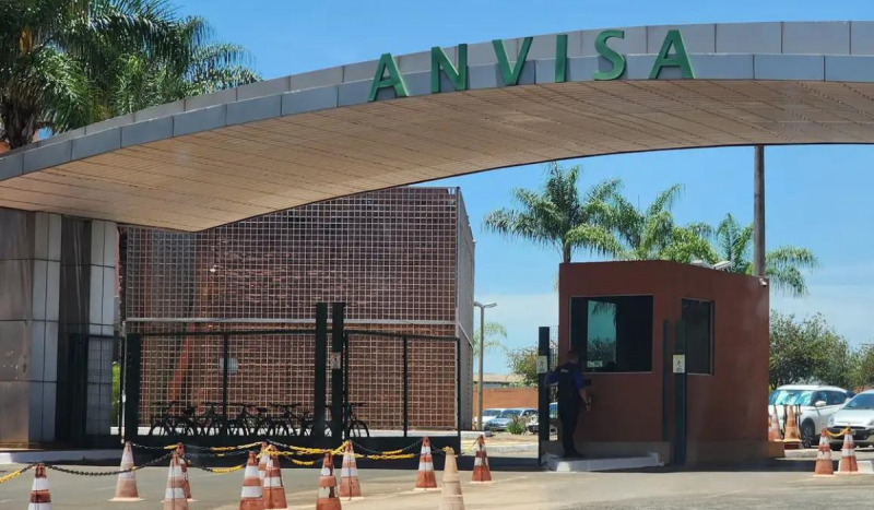 Fachada da Anvisa - foto mostra portal na entrada de prédio, acima de uma guarita de vigilantes