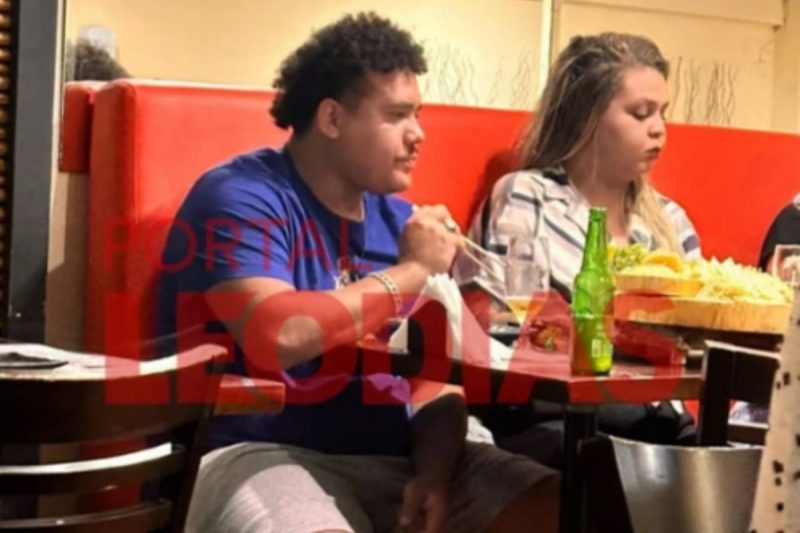 Lucas Buda acompanhado de uma mulher em restaurante