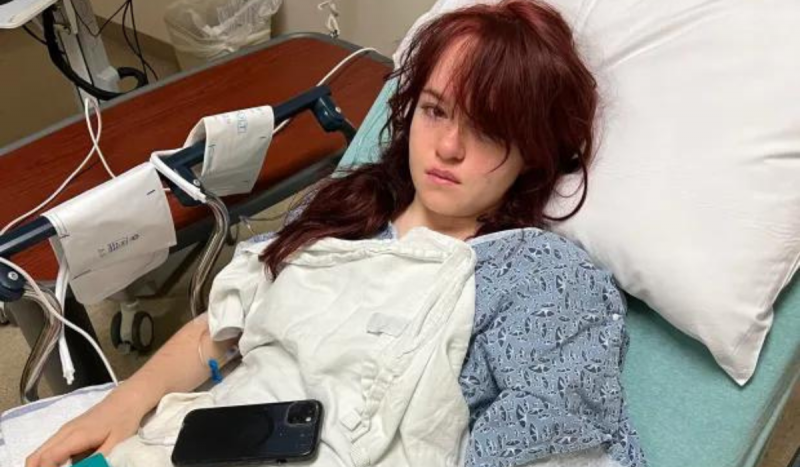 Foto mostra jovem de cabelo vermelho deitada em cama de hospital