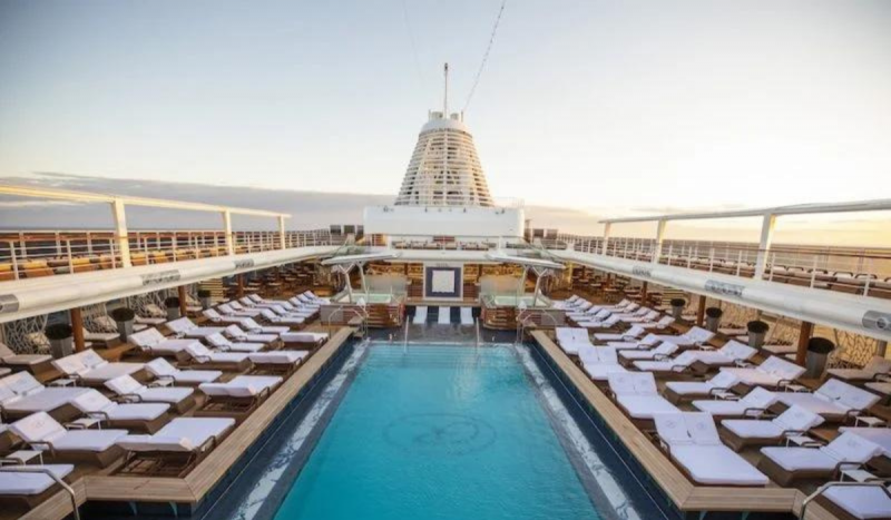 Piscina com várias cadeiras de praia dentro de cruzeiro de luxo 