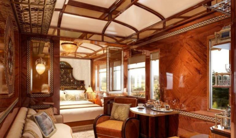 Foto mostra interior do trem de luxo que deve ser lançado no oriente médio. Na imagem é possível ver decoração marrom e dourada, com móveis brancos