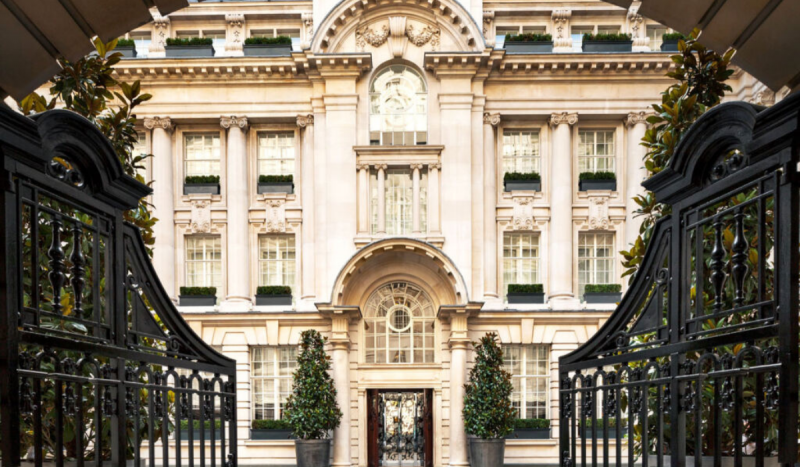 Fachada de clube de elite para ricaços. Foto mostra fachada de prédio com decoração clássica na cor bege e grades na cor preta
