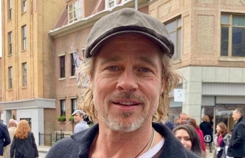 Brad Pitt de chapéu em rua movimentada