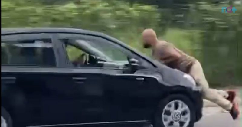 Frame de vídeo mostra momento exato em que homem que agrediu mulher foi arrastado por motorista em capô do carro
