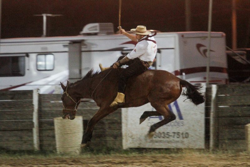 Foto mostra pessoa montada em cavalo em um rodeio do CTG Os Praianos