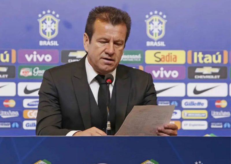 Ex-técnico da seleção Dunga em discurso em frente à banner dos patrocinadores da seleção de futebol