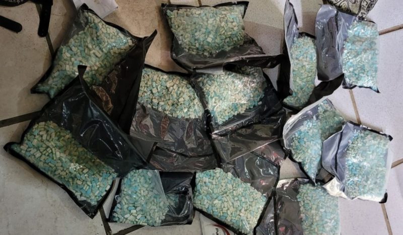 foto mostra diversos sacos com comprimidos de ecstasy jogados no chão